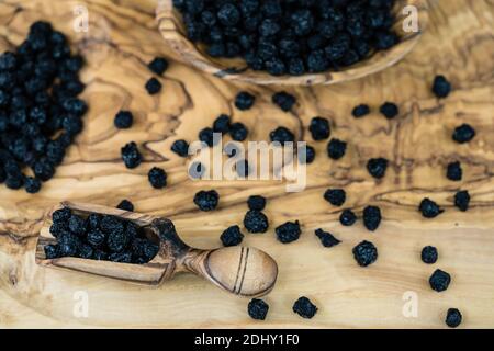 Getrocknete Schwarze Eberesche Aronia-Apfelbeere auf Olivenholz Stockfoto