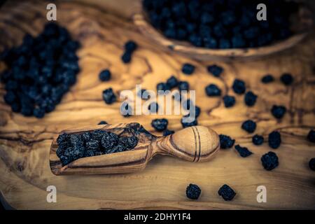 Getrocknete Schwarze Eberesche Aronia-Apfelbeere auf Olivenholz Stockfoto