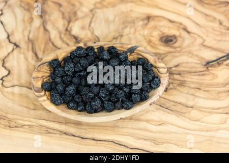 Getrocknete Schwarze Eberesche Aronia-Apfelbeere auf Olivenholz Stockfoto