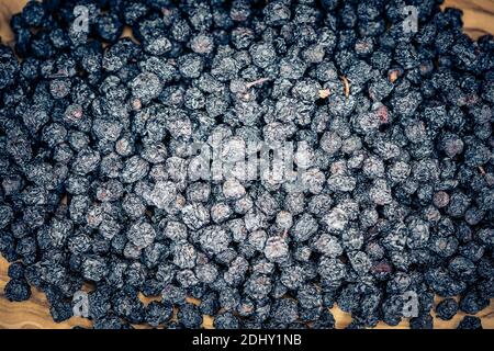 Getrocknete Schwarze Eberesche Aronia-Apfelbeere auf Olivenholz Stockfoto