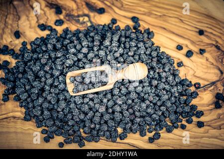 Getrocknete Schwarze Eberesche Aronia-Apfelbeere auf Olivenholz Stockfoto