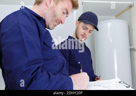 Techniker, die einen Warmwasserbereiter warten Stockfoto