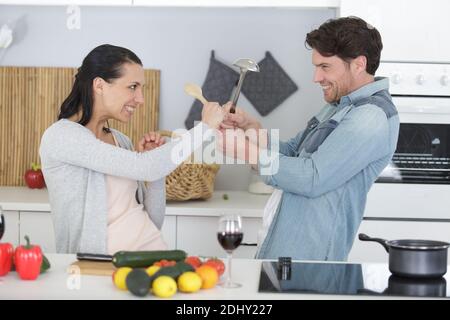 Lustige paar kämpft mit Utensilien Werkzeuge Stockfoto