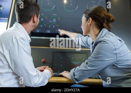 Mann und Frau benutzen den Bildschirm einer Maschine Stockfoto