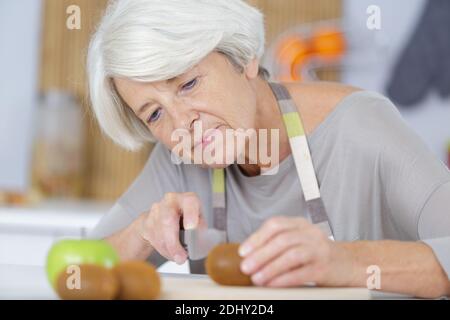Schöne reife Frau schneiden Tomaten Stockfoto