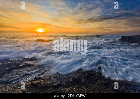 Malerischer, farbenfroher Sonnenaufgang über dem pazifischen Ozean am Turimetta Beach in Sydney, der australischen Stadt. Stockfoto