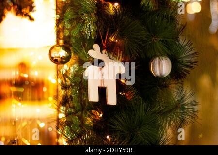 Weihnachtskarte mit Weihnachten Spielzeug, Tannenzweigen und girlande Bokeh. Einrichtung von tannenzweigen und des Neuen Jahres Einrichtung mit traditionellen Holzmöbeln Rotwild, klicken Sie Stockfoto