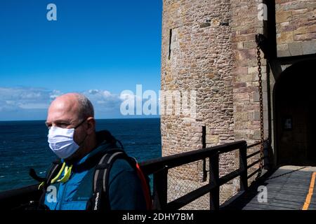 Obligatorische Maskenabnutzung und soziale Distanzierungsmaßnahmen in Fort La Latte in der Bretagne aufgrund der Covid-19 Pandemie. Port du Masque obligatoire et mesures Stockfoto