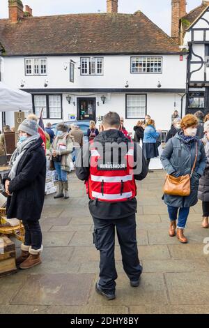 COVID-Botschafter unterstützen bei sozialer Distanzierung und tragen Gesichtsbezüge auf der Country Brocante Winter Fair, Market Square, Midhurst, West Sussex Stockfoto