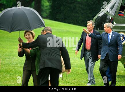 Der ehemalige Präsident der Vereinigten Staaten George H.W. Bush (2nd,R) geht mit US-Präsident George W. Bush als Helfer und hilft First Lady Laura Bush mit einem Regenschirm, als sie vom Wochenende auf der Ranch Crawford, Texas, am 11. Mai 2008 in Washington, DC, USA, im Weißen Haus ankommen. Bush, dessen Tochter Jenna Henry Hager auf der Ranch heiratete, beschrieb die Erfahrung als "speziell" und "es ist alles, was wir uns erhofft haben". Foto von Mike Theiler/CNP/ABACAPRESS.COM Stockfoto