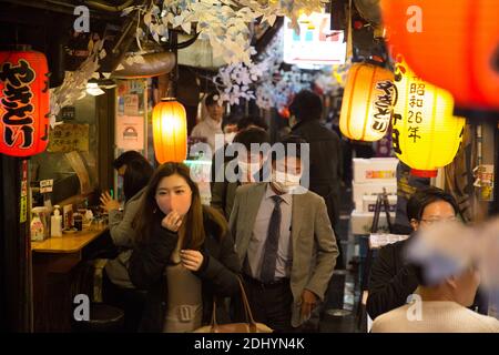 Tokio, Japan. Dezember 2020. Besucher, die Gesichtsmasken tragen, gehen durch eine enge Straße eines Nachtbezirks in Shinjuku. Quelle: Stanislav Kogiku/SOPA Images/ZUMA Wire/Alamy Live News Stockfoto