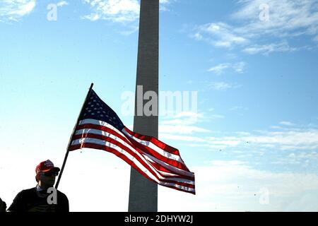 Washington, DC, USA. Dezember 2020. Präsident Trumps Unterstützer hält am 12. Dezember 2020 in Washington DC eine amerikanische Flagge gegen das George Washington Monument. Die Unterstützer unterstützen weiterhin die unbewiesenen Behauptungen des Präsidenten über massiven Wahlbetrug und Unregelmäßigkeiten bei den Wahlen. Nach der MAGA-Kundgebung im November in Washington hat Women for America First, eine konservative Organisation, eine weitere Erlaubnis zur Kundgebung zur Unterstützung von Präsident Trump beantragt, nur zwei Tage bevor die Wähler aus jedem Staat für ihre Kandidatur stimmen. Quelle: SIPA USA/Alamy Live News Stockfoto