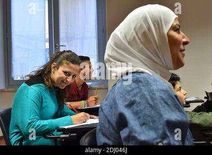 Syrischer Flüchtling Nour Essa,30 (links) in der sprach- und Kulturschule der katholischen Gemeinschaft Sant' Edigio in Rom, Italien am 21. April, 2016.die Gemeinschaft Sant'Egidio organisiert Italienisch-Unterricht für die 3 Familien von 12 Syrern, die von Papst Franziskus aus einem griechischen Lager geplünzt und mit der Wohltätigkeitsorganisation Sant'Edigio in Roms Stadtteil Trastevere platziert wurden. Alle drei Familien sahen ihre Häuser in Syrien bombardiert und alle drei kamen aus der Türkei auf überladenen Gummibooten in Griechenland an. Jetzt beginnen die Familien eine neue Reise: Sprachunterricht und Integration in eine neue Kultur. Nour Essa hatte es Stockfoto