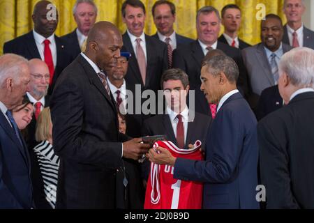 US-Präsident Barack Obama erhält ein Trikot von Thurl Bailey (L), nachdem er ehemalige Spieler und Mitarbeiter der NCAA National Basketball Championship North Carolina State Wolfpack 1983 im East Room des Weißen Hauses in Washington, DC, USA, am 09. Mai 2016 begrüßt hat. Der Präsident und Vizepräsident trafen sich kurz mit Mitgliedern des Teams und ihren Familien im East Room. Das Team war bisher nicht in der Lage, das Weiße Haus zu besuchen, um für ihre Meisterschaft anerkannt zu werden. Foto von Pool/ABACAPRESS.COM Stockfoto