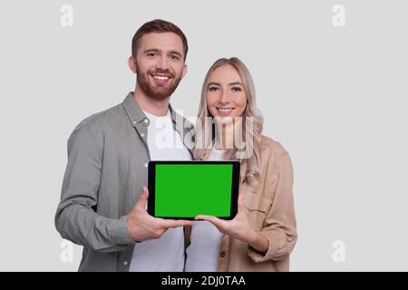 Paar Zeigt Tablet Green Screen Isoliert Stehend. Konzept Für Werbung, Werbung Und Werbung Stockfoto