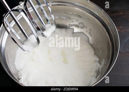 Schlagen von Eiweiß zu Meringue: Eiweiß, das in einem Standmixer geschlagen wurde, bis sie flauschig sind Stockfoto