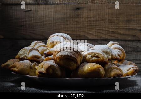 Hausgemachte Kekse in Form von Bagels mit Marmelade Füllung bestreut mit Puderzucker auf einem hölzernen Hintergrund. Selektiver Fokus. Stockfoto