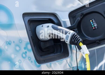 E-Auto beim Aufladen - Elektroauto angesteckt bei der Ladestation Stockfoto