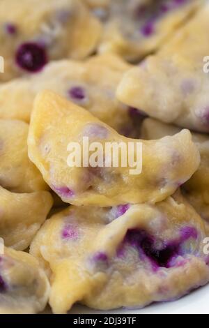 Vertikale und Nahaufnahme von Knödeln mit Heidelbeeren oder Beeren. Stockfoto