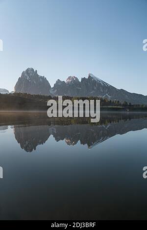 Langkofel und Plattkofel spiegeln sich im kleinen See, Seiser Alm, Südtirol, Italien Stockfoto