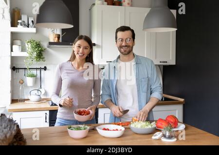 Portrait lächelnde Frau und Mann stehen in der Küche, kochen zusammen Stockfoto