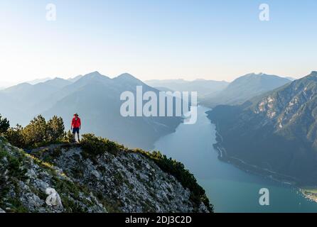 Junger Mann auf dem Baerenkopf, Blick auf den Achensee, links Seekarspitze und Seebergspitze, Karwendel, Tirol, Österreich Stockfoto