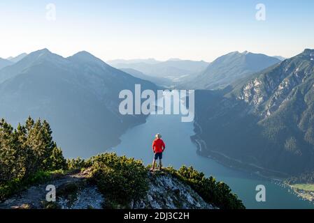 Junger Mann mit Blick auf die Berglandschaft, Blick vom Baerenkopf auf den Achensee, links Seekarspitze und Seebergspitze, Karwendel Stockfoto