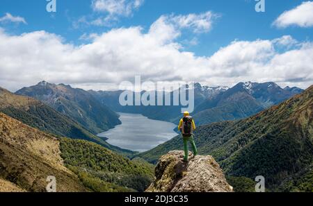 Bergsteiger, Wanderer in die Ferne schauen, Blick auf den Südford des Lake Te Anau, Murchison Mountains und Southern Alps im Hintergrund, auf Stockfoto