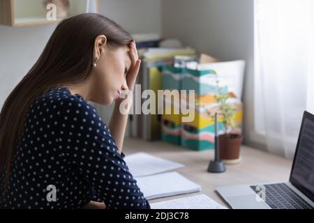 Nahaufnahme erschöpfte Frau, die unter Kopfschmerzen leidet und die Stirn berührt Stockfoto