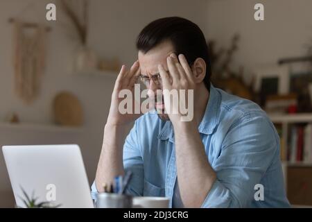 Nahaufnahme ungesunder Mann mit Brille, der an Kopfschmerzen leidet Stockfoto