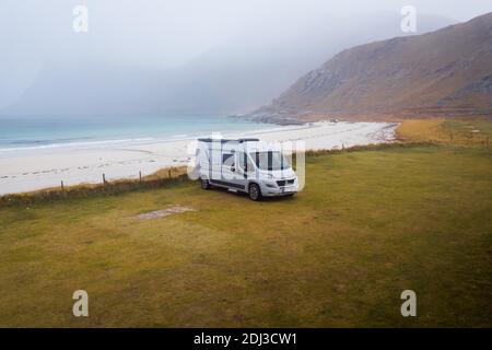 Drohnenschuss, Camping-Van auf Gras vor einem feinen Sandstrand, Haukland Strand, Lofoten, Norwegen Stockfoto