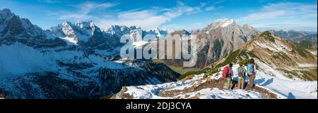 Drei Wanderer auf Wanderweg mit Schnee im Herbst, Wanderung zum Gipfel des Hahnenkampl, Blick auf schneebedeckte Gipfel Laliderspitze, Dreizinkenspitze Stockfoto