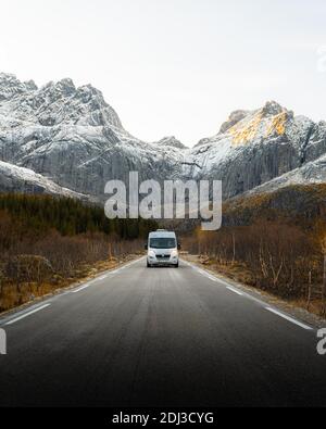 Wohnmobil auf einer Straße vor einem Berg in der Nähe von Nusfjord, Lofoten, Norwegen Stockfoto