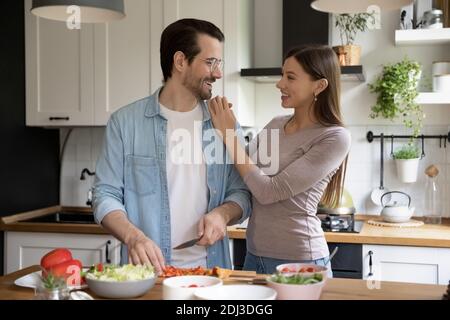 Glückliches junges Paar umarmt, genießen Freizeit in der Küche, Kochen Stockfoto