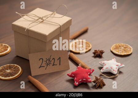 Weihnachts-Geschenkbox aus umweltfreundlichem Papier mit Naturgarn auf Holztisch mit natürlichen Dekorationen und 2021 Karte, flacher Fokus verpackt