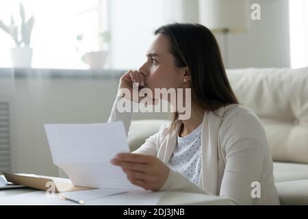 Nahaufnahme nachdenklich frustriert junge Frau hält Papier Brief Stockfoto