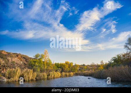 Ein Bach fließt zwischen riesigen Steinen mit kleinen trockenen Pflanzen im warmen Abendlicht in der malerischen Ukraine bedeckt. Luftdrohne erschossen Stockfoto