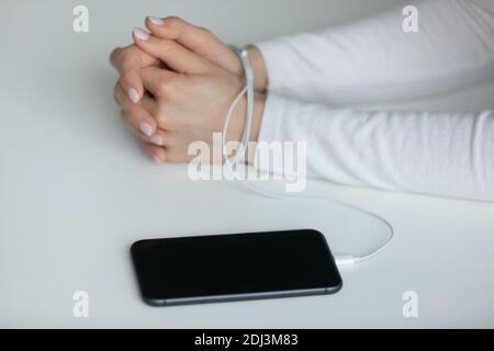 Nahaufnahme junge Frau mit Händen in Kabel gewickelt Stockfoto