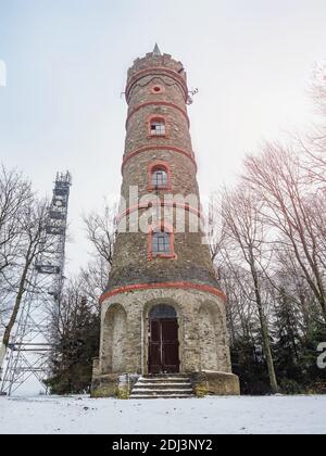 Aussichtsturm Jedlova. Der steinerne historische Aussichtsturm auf dem Hügel Jedlova am frühen Wintersonntag. Stockfoto