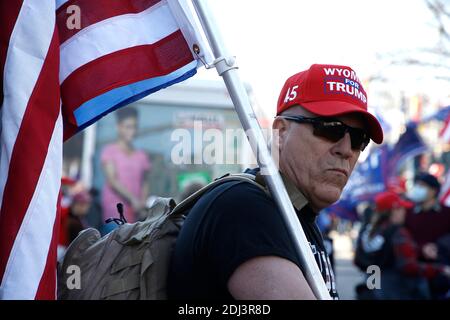 Präsident Trumps Unterstützer haben gesehen, dass er während der Kundgebung in Freedom Plaza eine Trump-Anhängerkappe trug und eine amerikanische Flagge hielt.die Unterstützer unterstützen weiterhin die unbewiesenen Behauptungen des Präsidenten über massiven Wahlbetrug und Unregelmäßigkeiten bei den Wahlen. Nach der im November IN WASHINGTON VERSAMMELTEN MAGA-Kundgebung (Make America Great Again) hat Women for America First, eine konservative Organisation, eine weitere Genehmigung zur Kundgebung zur Unterstützung von Präsident Trump beantragt, nur zwei Tage bevor die Wähler aus jedem Staat für ihre Kandidatur stimmen. Stockfoto