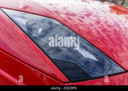 Nahaufnahme der Scheinwerfer-Cluster und Motorhaube auf Die Vorderseite eines Rosso Mars roten Lamborghini Huracan Spyder LP 580-2 Stockfoto