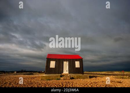 Rye Harbour, 12. Dezember 2020: Sturmwolken sammeln sich über der ikonischen, rot überdachten Hütte, die am Kiesstrand am Eingang zum Rye Harbour liegt.Quelle: Andrew Hasson/Alamy Live News Stockfoto