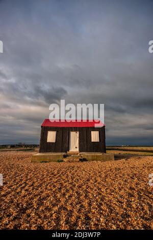 Rye Harbour, 12. Dezember 2020: Sturmwolken sammeln sich über der ikonischen, rot überdachten Hütte, die am Kiesstrand am Eingang zum Rye Harbour liegt.Quelle: Andrew Hasson/Alamy Live News Stockfoto