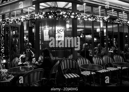 PARIS, FRANKREICH - 2. DEZEMBER 2018: Pariser und Touristen trinken abends im Café Panis (bereits zu Weihnachten dekoriert) in der Nähe von Notre-Dame Stockfoto