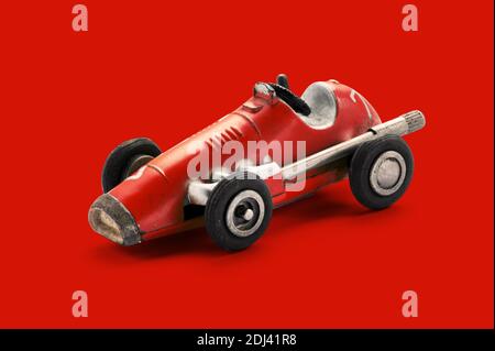 Vintage rot Spielzeug Rennwagen, Seitenansicht auf rotem Hintergrund Stockfoto