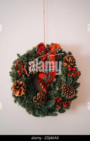 Weihnachtskrone und Winterkranz Dekoration mit Stechpalme, Tanne, blauer Fichte, Tannenzapfen auf weißem Hintergrund. Stockfoto