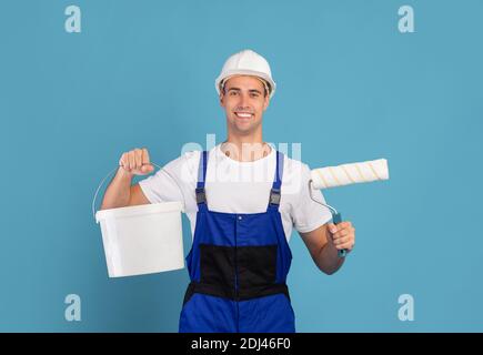 Painter Guy. Lächelnd Male Repair Master Holding Eimer Und Ausrüstung Für Die Malerei Stockfoto