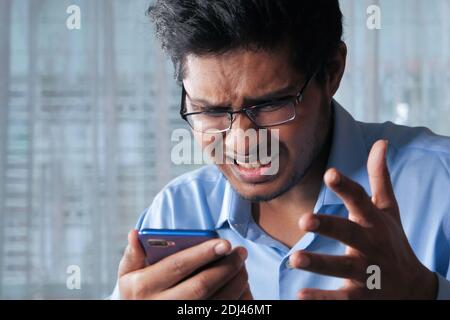 Verärgert Mann lesen schlechte Nachrichten auf Smartphone Stockfoto