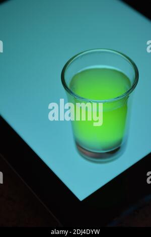 Glas Limoncello auf hellblauem Hintergrund Stockfoto