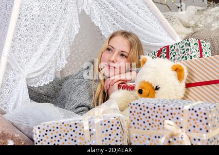 Hübsche Dame Frau legen auf Weihnachten geschenkboxen tragen weiß gestrickt pullover Stockfoto